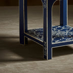 Blue chair with intricate white patterns on a brown carpet