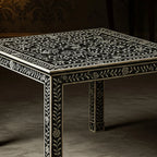 Decorative black table with white floral patterns on a dark background