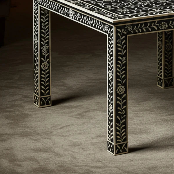 Decorative table with intricate black and white patterns on a dark surface