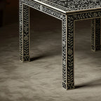 Decorative table with intricate black and white patterns on a dark surface