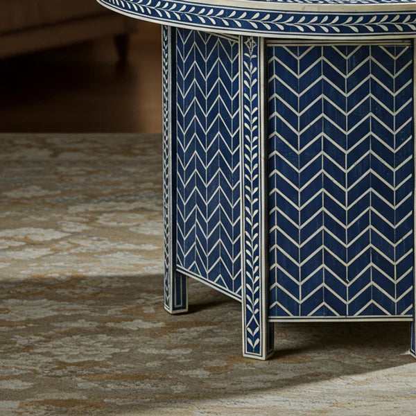 Decorative side table with blue and white chevron pattern on a textured floor.